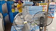 File : Un employé de magasin remplit un rayon avec des produits de climatisation pour l’été, à Marseille, dans le sud de la France, le 3 juillet 2015.