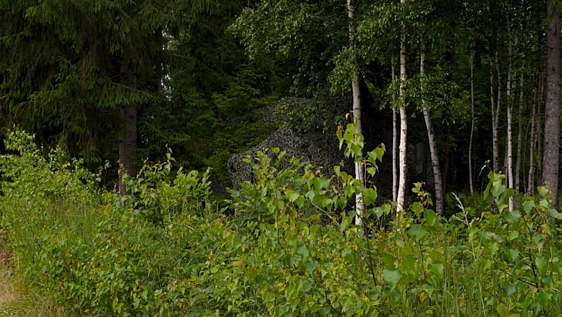 Von außen ist die Stellung der Einheit getarnt. Je weiter man sich entfernt, desto mehr verschmilzt die Plane mit dem Wald.