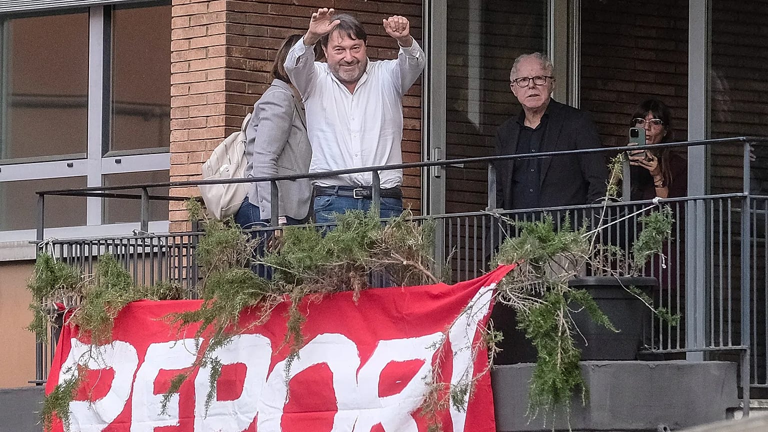 Investigative journalist Sigfrido Ranucci waves from a balcony at the RAI State TV headquarters, hours after an explosive device detonated under his car in Pomezia