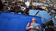 La residente Kerli Faria descansa entre los escombros mientras busca a sus sobrinos en un edificio que se derrumbó durante los terremotos que azotaron La Guaira, 30/06/2026.