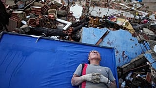 La residente Kerli Faria descansa entre los escombros mientras busca a sus sobrinos en un edificio que se derrumbó durante los terremotos que azotaron La Guaira, 30/06/2026.