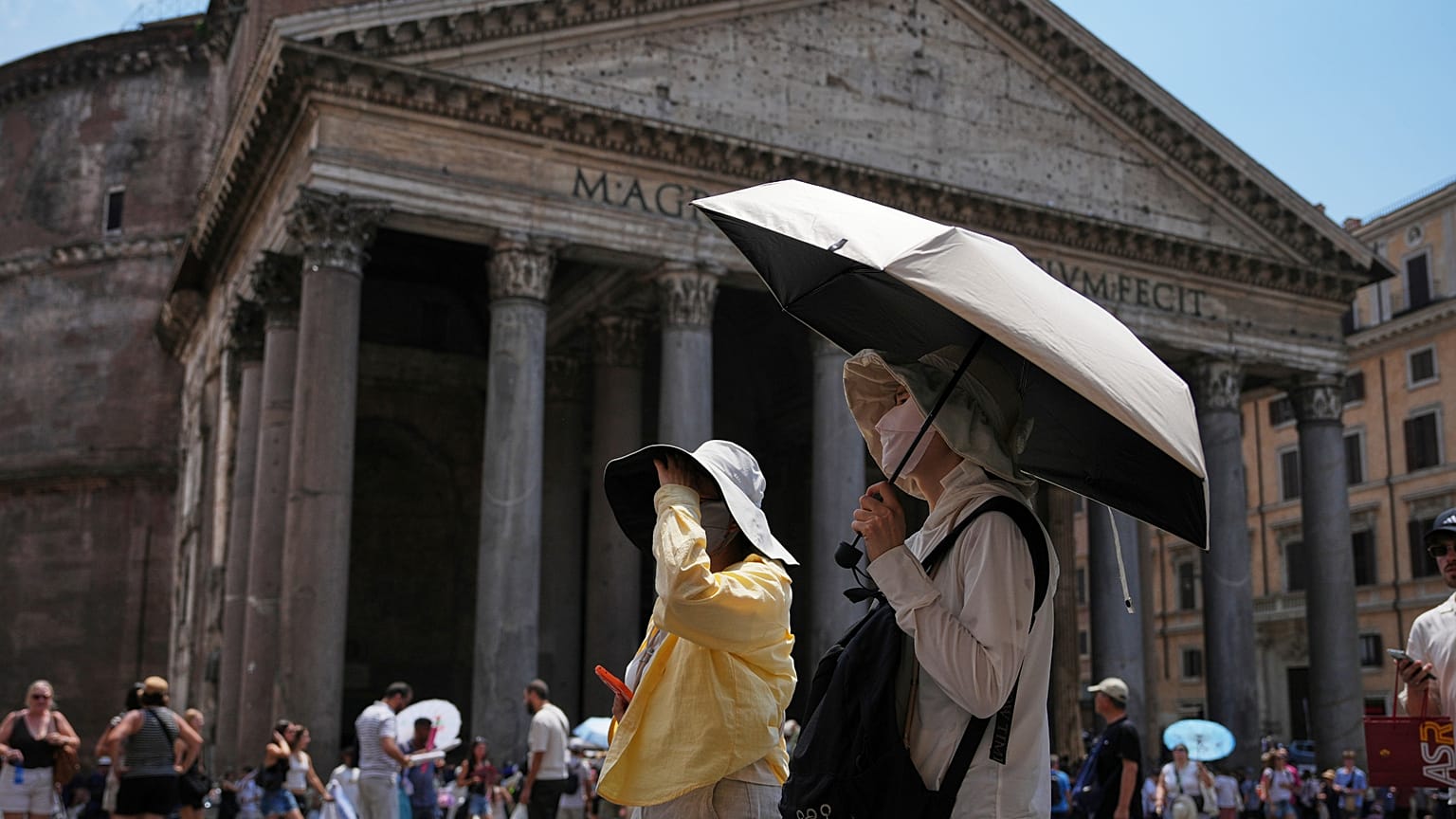 Turisti cercano di difendersi dal caldo di fronte al Pantheon, a Roma, il 29 giugno 2026