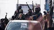 عناصر من كتائب عز الدين القسام يشاركون في عرض عسكري احتفالاً باتفاق وقف إطلاق النار بين حماس وإسرائيل في دير البلح، وسط قطاع غزة، 19 كانون الثاني 2025.
