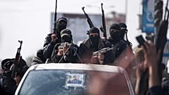 عناصر من كتائب عز الدين القسام يشاركون في عرض عسكري احتفالاً باتفاق وقف إطلاق النار بين حماس وإسرائيل في دير البلح، وسط قطاع غزة، 19 كانون الثاني 2025.