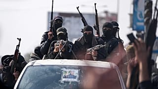 عناصر من كتائب عز الدين القسام يشاركون في عرض عسكري احتفالاً باتفاق وقف إطلاق النار بين حماس وإسرائيل في دير البلح، وسط قطاع غزة، 19 كانون الثاني 2025.