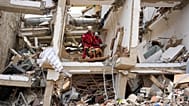 Unos rescatistas, peinan las ruinas de un edificio