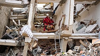 Unos rescatistas, peinan las ruinas de un edificio