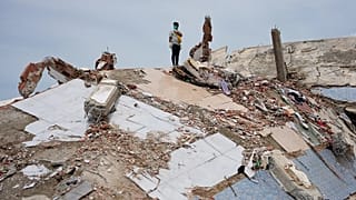 A man stands atop the rubble of a building that collapsed in the earthquakes in La Guaira, Venezuela, Tuesday, June 30, 2026.