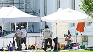 A National Park Service employee cools off while working near the North Portico of the White House, during a heatwave, Tuesday, June 30, 2026, in Washington.