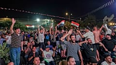 Iraki futballszurkolók reagálnak, miközben Bagdad belvárosában, egy kivetítőn nézik az Irak–Norvégia vb-meccset 2026. június 17-én, szerdán hajnalban.