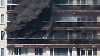 Rescue workers look for victims on upper floors after an apartment block fire in Linkeroever, 1 July, 2026