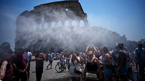 People cool off in front of a water-spraying cannon set up by Rome's municipality to relieve tourists at the Colosseum and Roman Forum, Rome, Friday, June 26, 2026