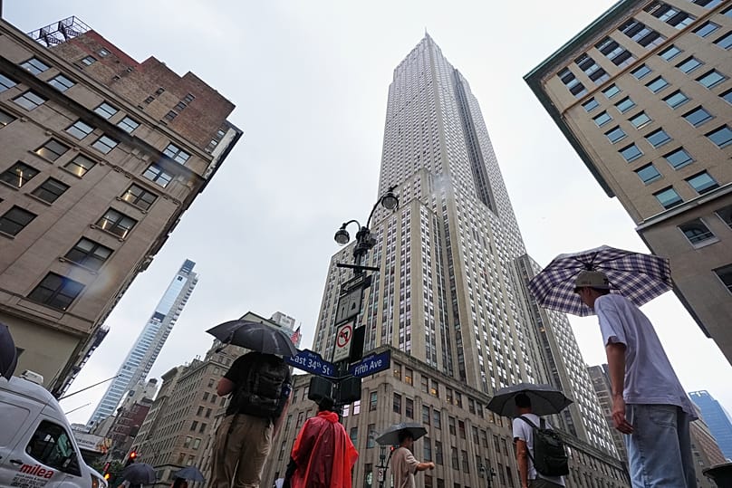 Pedestrians walk past the Empire State Building in New York, 31 July, 2025