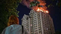 امرأة تنظر إلى مبنى سكني يشتعل بعد هجوم صاروخي روسي على كييف في أوكرانيا، الخميس الثاني من يوليو 2026.