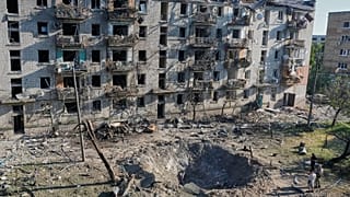 People look at the site of a Russian missile strike that hit a residential building in Kyiv, 2 July, 2026