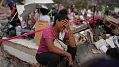 Los Angeles County İtfaiyesi görevlileri, Venezuela’daki La Guaira’yı vuran depremler sonrası çöken binada hayatta kalanları ararken Khaterine Roa ağlıyor.