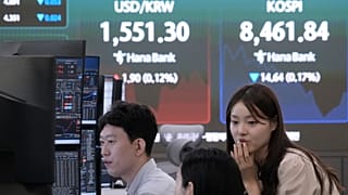 Currency traders work near a screen showing the Korea Composite Stock Price Index (KOSPI) in the Hana Bank headquarters in Seoul, South Korea, 1 July 2026
