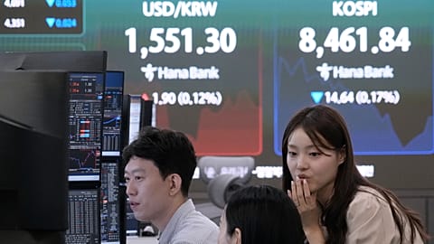Currency traders work near a screen showing the Korea Composite Stock Price Index (KOSPI) in the Hana Bank headquarters in Seoul, South Korea, 1 July 2026