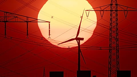 The sun rises behind power poles and a wind turbine in Frankfurt, Germany, early Saturday, July 27, 2019. 
