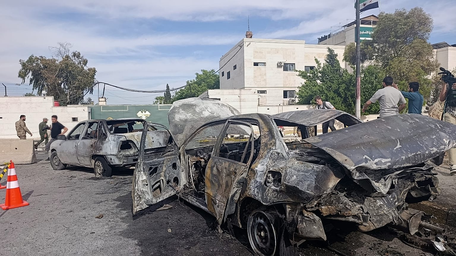 أفراد الأمن السوريون يتفقدون موقع الانفجار خارج مبنى وزارة الدفاع في دمشق، سوريا، الثلاثاء 19 مايو 2026. 