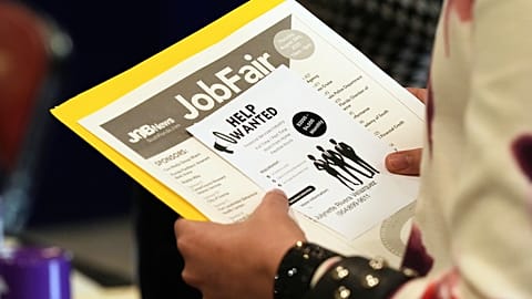 FILE. A job seeker waits to talk to a recruiter at a job fair in Sunrise, Florida, Aug. 2025