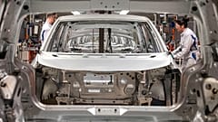 Operai completano un'auto elettrica sulla linea di montaggio in uno stabilimento della Volkswagen in Germania