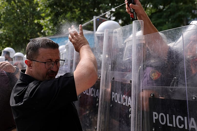 A riot police officer uses pepper spray against a protester during clashes at an anti-government rally in Tirana, 2 July, 2026
