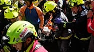 Rescue workers carry Hernán Alberto Gil Flores Gil after he was pulled from the rubble eight days after he was trapped by twin earthquakes, 2 July, 2026