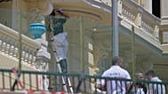 An investigator examines the scene at the residential building where an explosive device seriously injured three people a day earlier in Monaco, Tuesday, June 30, 2026.