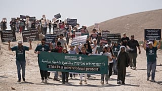 Attivisti israeliani e internazionali per la pace manifestano venerdì 12 giugno 2026 a sostegno delle comunità beduine di Khan al-Ahmar, in Cisgiordania occupata.