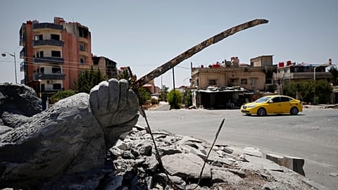 صورة أرشيفية - سيارة تمر بجوار تمثال مدمر في مدينة السويداء ذات الأغلبية الدرزية، سوريا، الجمعة 25 يوليو/تموز 2025. (صورة من وكالة أسوشيتد برس/عمر سناديكي، أرشيفية)
