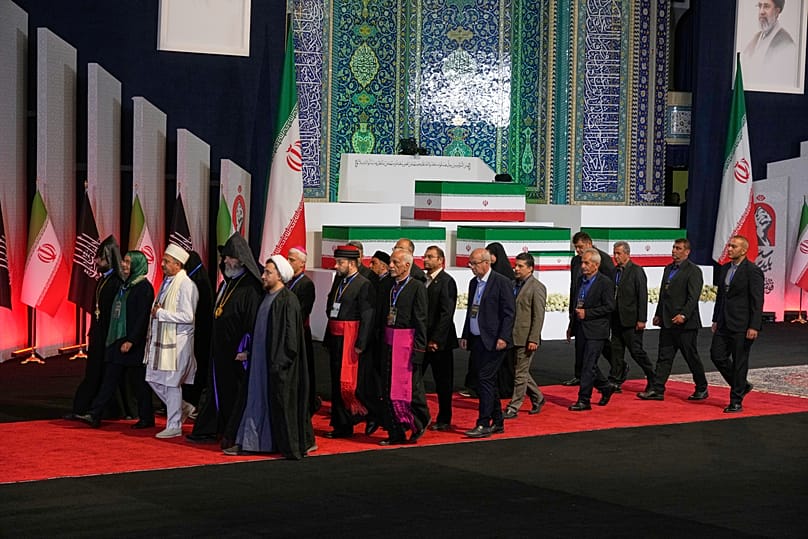 Leader religiosi iraniani passano accanto alle bare di Ali Khamenei e dei suoi familiari durante una cerimonia alla Grande moschea Imam Khomeini Mosalla di Teheran, 3 luglio 2026