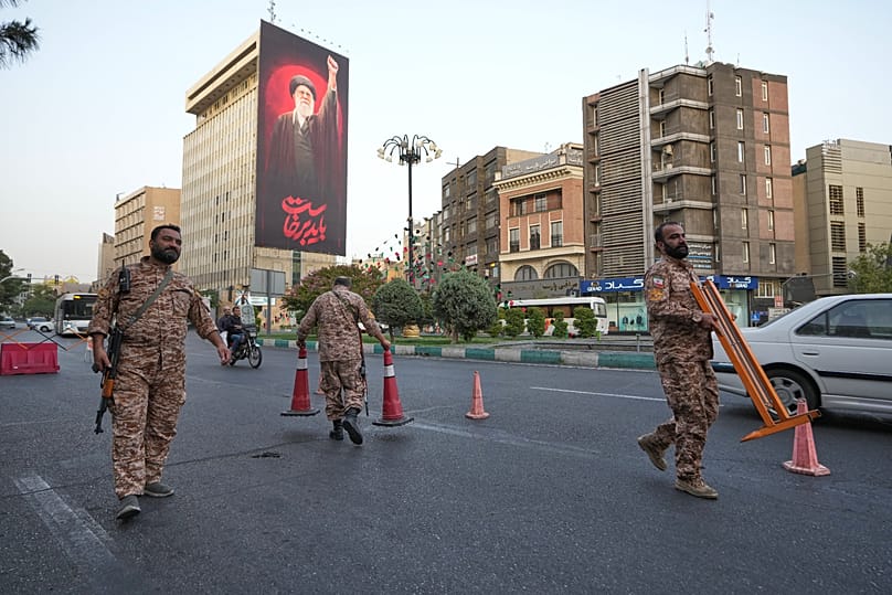 أقامت قوات الباسيج شبه العسكرية الإيرانية نقطة تفتيش في ساحة قبل مراسم جنازة المرشد الأعلى المقتول آية الله علي خامنئي، التي تظهر على اللوحة الإعلانية في الخلف 