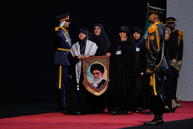 تحمل النساء صورة المرشد الأعلى الإيراني المقتول آية الله علي خامنئي عند وصولهن لتقديم احتراماتهن أمام توابيت خامنئي وأفراد عائلته خلال حفل مشاهدة قبل مراسم الجنازة