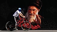 رجل يركب دراجة أمام صورة المرشد الأعلى الإيراني المقتول آية الله علي خامنئي قبل مراسم جنازته التي استمرت أيامًا في طهران، إيران، الجمعة 3 يوليو 2026