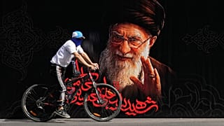 رجل يركب دراجة أمام صورة المرشد الأعلى الإيراني المقتول آية الله علي خامنئي قبل مراسم جنازته التي استمرت أيامًا في طهران، إيران، الجمعة 3 يوليو 2026