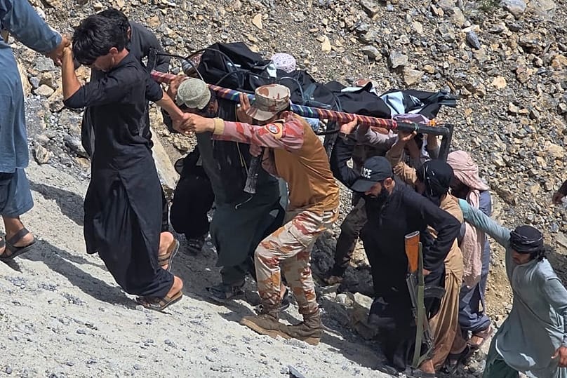 Soldiers and volunteers transport a body after recovering him from a bus crash in Dana Sar, 3 July, 2026