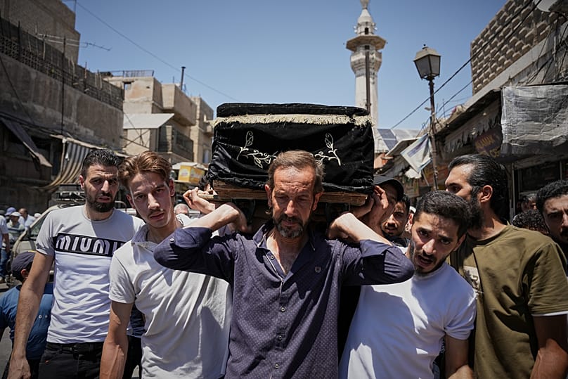 Mourners carry the coffin of one of the victims of an explosive device detonated in a cafe near Damascus' main courthouse, 3 July, 2026