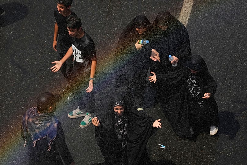 يبرد المشيعون تحت رذاذ الماء أثناء سيرهم إلى مسجد الإمام الخميني مصلى الكبير خلال مراسم جنازة المرشد الأعلى الإيراني الراحل آية الله علي خامنئي التي استمرت أيامًا في طهران