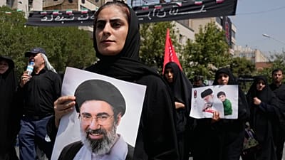 سيدة إيرانية تحمل صورة آية الله مجتبى خامنئي أثناء توجهها إلى مسجد مصلى الإمام الخميني في طهران خلال مراسم جنازة والده آية الله علي خامنئي، السبت 4 يوليو/تموز 2026.