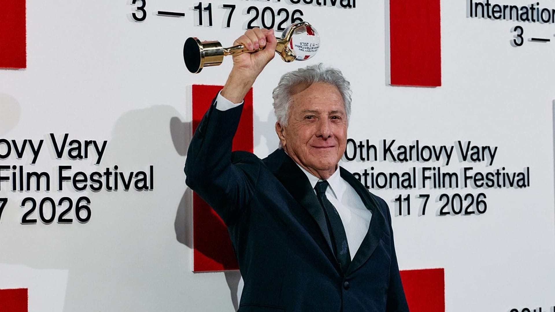 A kétszeres Oscar-díjas színész, Dustin Hoffman Karlovy Varyban magasba emeli Kristályglóbuszát a világ filmművészetéhez való művészi hozzájárulásáért, 2026. július 3-án.