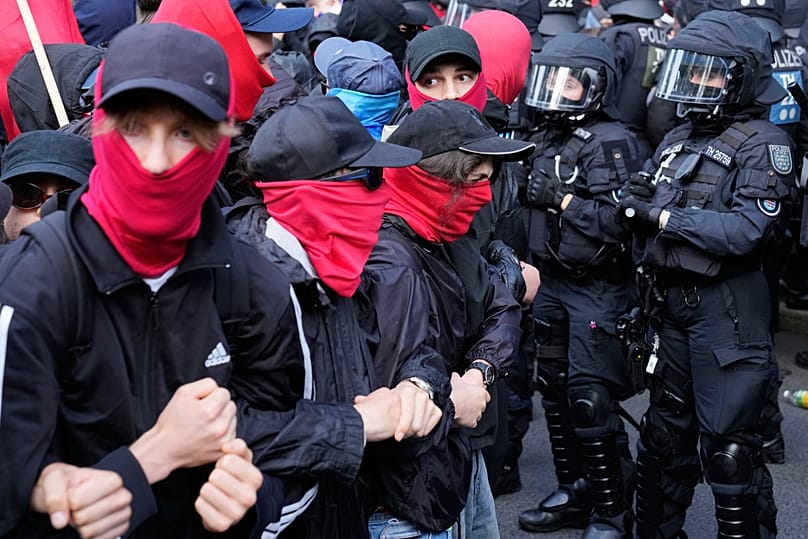 Polizeikräfte, rechts im Bild, sichern eine Kundgebung gegen einen Parteitag der Alternative für Deutschland (AfD) in Erfurt, Deutschland, am Samstag, den 4. Juli 2026.