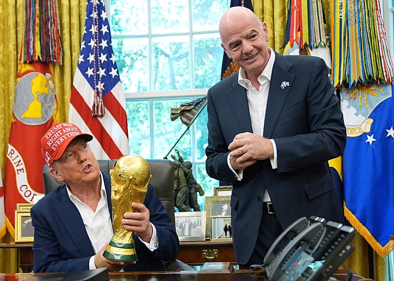 FILE - President Donald Trump holds the FIFA World Cup Winners Trophy as FIFA President Gianni Infantino n the Oval Office of the White House, Aug. 22, 2025, in Washington. 