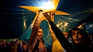 Demonstrators standing under a large European Union flag during a pro-EU rally in Bucharest, Romania, on 9 May, 2025.