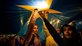 Demonstrators standing under a large European Union flag during a pro-EU rally in Bucharest, Romania, on 9 May, 2025.