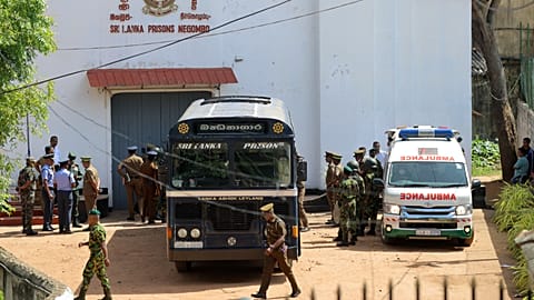 Security personnel stand guard in the compound of a prison where deadly clashes broke out in Negombo, 6 July, 2026