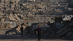 Palestinians walk along a road surrounded by buildings destroyed in Israeli military strikes in Jabaliya, 2 July, 2026