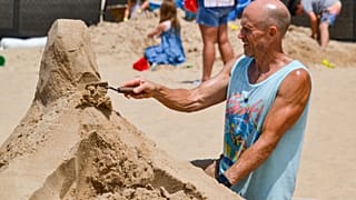 Michigan City, Indiana, USA, 18. Juli 2025: Der semiprofessionelle Bildhauer Ben Reed aus Greentown arbeitet an seiner Sandskulptur beim Singing Sands Festival in Washington.