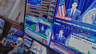 المؤتمر الصحفي لرئيس مجلس الاحتياطي الفدرالي كيفن وورش يظهر على الشاشات في قاعة بورصة نيويورك يوم 17 يونيو 2026