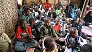 طلاب سودانيون غادروا السودان خلال الحرب الأهلية يستمعون إلى معلمهم في مدرسة للاجئين تضم نحو 73 طفلاً، في تاجوراء، شرق طرابلس، ليبيا، الاثنين 18 مايو 2026.